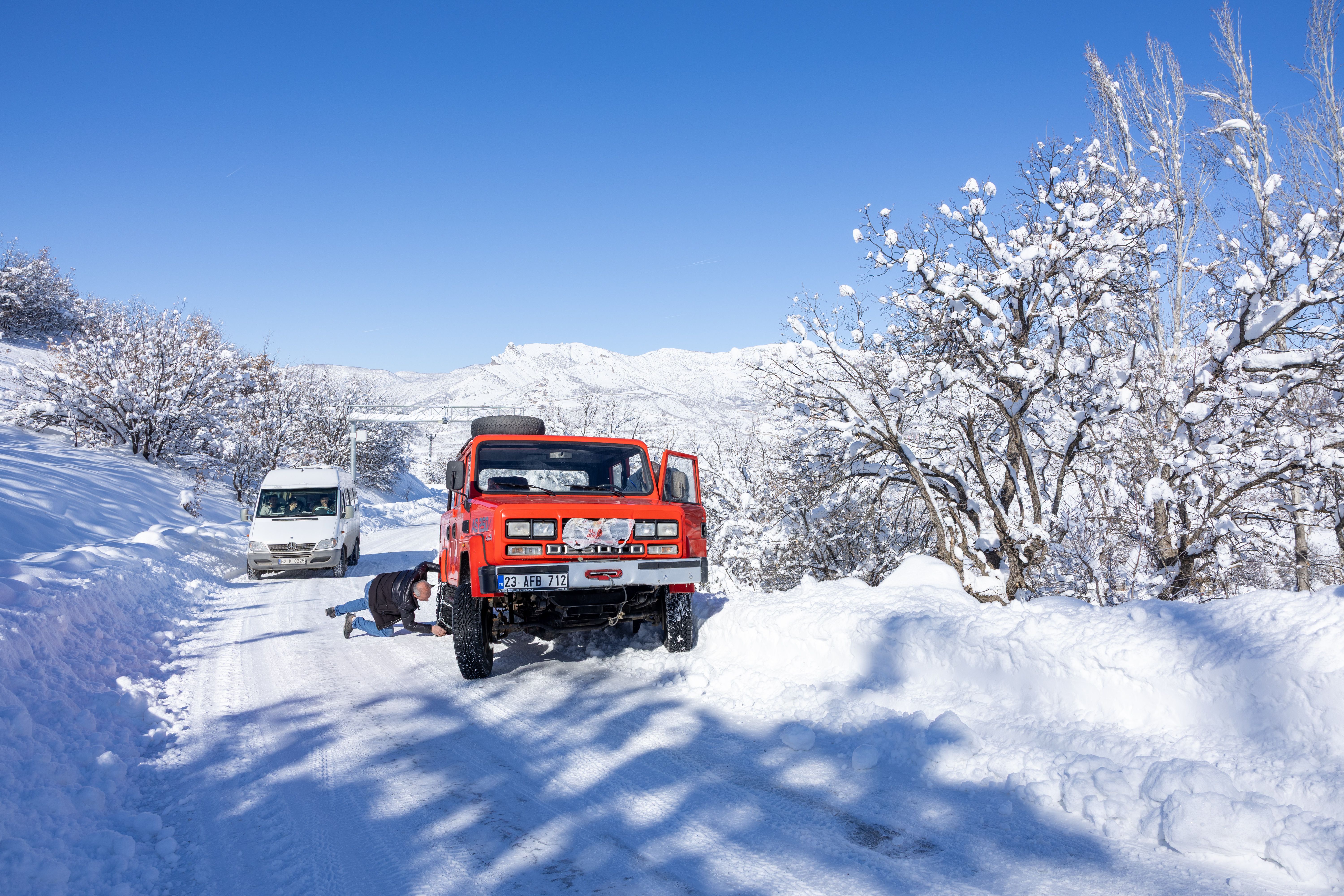 Truck stopped on the roadside with a mechanic repairing underneath the vehicle on-site
